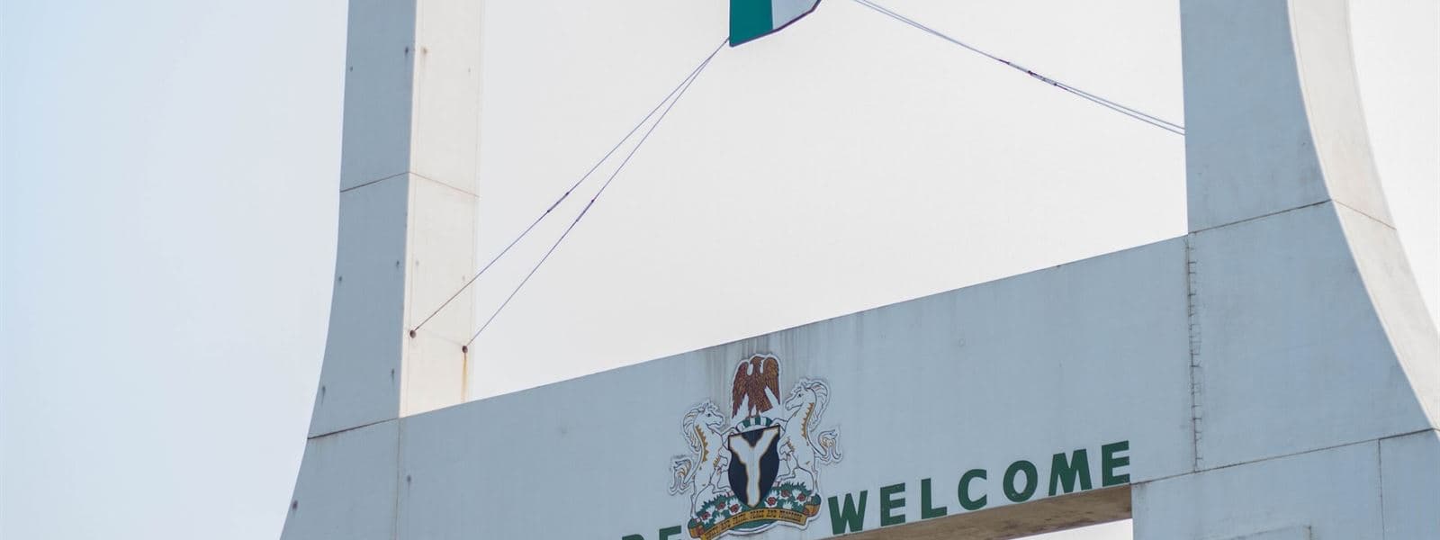 The City Gate in Abuja with the Nigerian flag and the words “You are welcome”