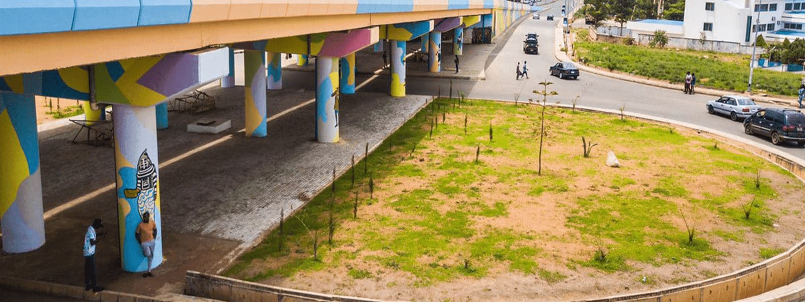 A colourfully painted flyover and green roundabout in Jos