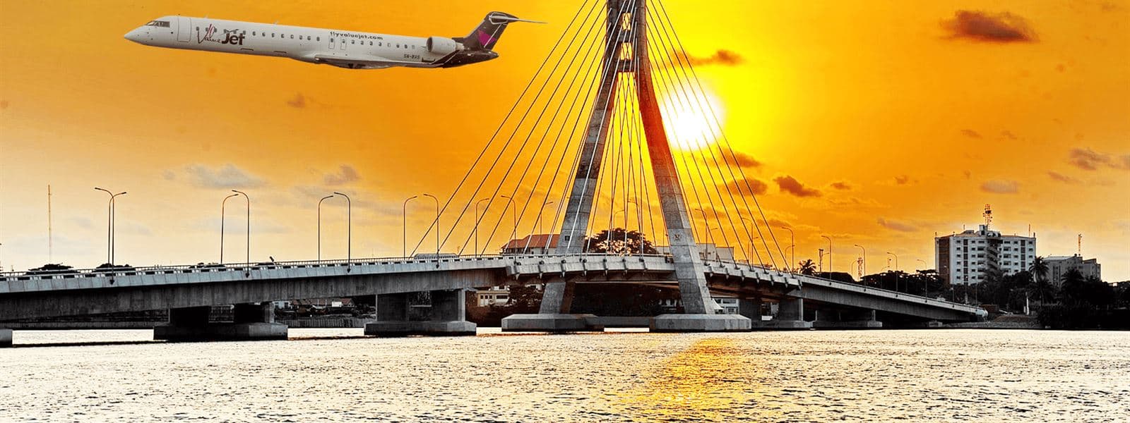 A ValueJet jet flying past the Lekki–Ikoyi Link Bridge in Lagos at sunset